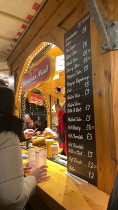 a woman sitting at a counter in front of a menu