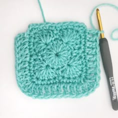 a crochet square with a knitting needle next to it