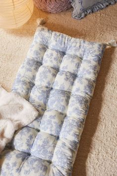 a blue and white chair cushion sitting on the floor