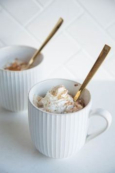 two white mugs filled with hot chocolate and whipped cream