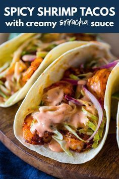 three chicken tacos with creamy srirac sauce on a wooden platter and text spicy shrimp tacos