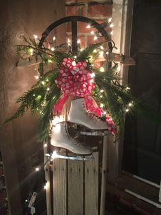 an image of a christmas decoration with lights on the window sill and boots in front of it