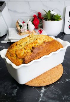 a loaf of bread sitting on top of a counter next to a potted plant