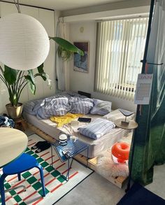 a living room filled with furniture next to a window covered in curtains and pillows on top of a rug