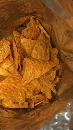 some chips are in a plastic bag on the table and it looks like they have been cooked