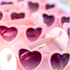 pink heart shaped sunglasses sitting on top of a table