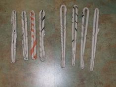 five toothbrushes are lined up on the floor with orange and white striped handles