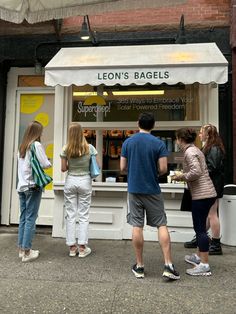 people standing in front of a lemon bagel shop