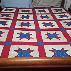 a red, white and blue quilted bed spread with stars on the bottom half