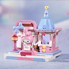 a pink and blue toy house with a mouse on the front door, next to it's windows