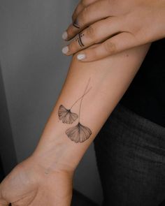 a woman's arm with two butterfly tattoos on it