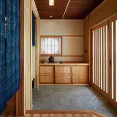 an empty room with wood paneling and blue curtains