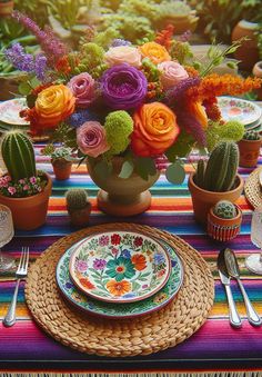 a colorful table setting with flowers and cactus in the center, plates and utensils