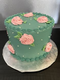 a green cake with pink roses on it