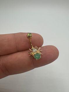 a person is holding an emerald and diamond nose ring in their left hand, while the third one has a gold star on it