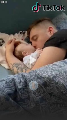 a man is sleeping with his baby in bed