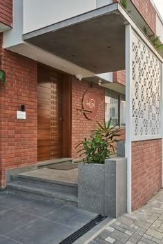 an entrance to a brick building with a planter on the sidewalk