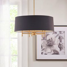 a black and gold chandelier hangs from the ceiling in front of a window