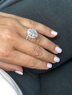 a close up of a person's hand with a diamond ring on their finger