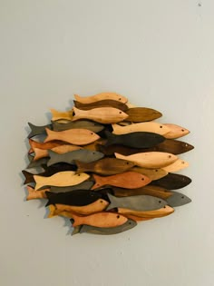 a group of wooden fish mounted to the side of a wall next to a white wall