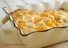 a casserole dish with oranges and cheese in it on a wooden table