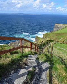 stairs lead down to the ocean from a grassy hill