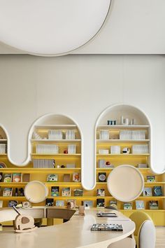 an office with yellow shelves and white chairs