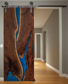 a wooden door with blue water painted on it in an empty room next to a hallway