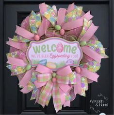 a welcome wreath with pink bows and an easter egg on it that says, we've been expecting you