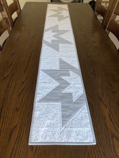 a table runner with an arrow and the word may on it is sitting on top of a wooden dining room table