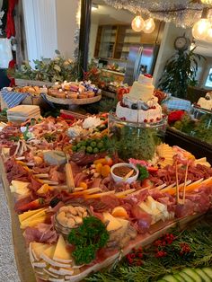 an assortment of meats and cheeses on display in a buffet area at a restaurant