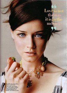 a woman with blue eyes is holding an apple