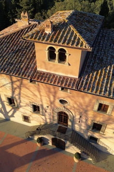 an aerial view of a building with tiled roof and windows on the top floor is shown