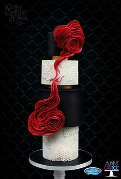 a three tiered cake with red and black icing on it's sides