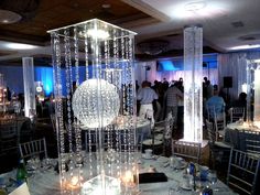 a room filled with lots of tables covered in white table cloths and centerpieces