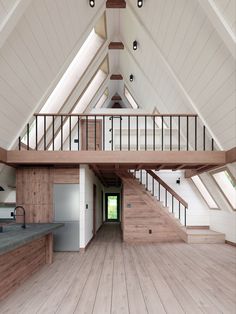 an empty room with wooden floors and white walls is shown in this image, there are stairs leading up to the second floor