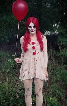 a woman with red hair and makeup holding a balloon