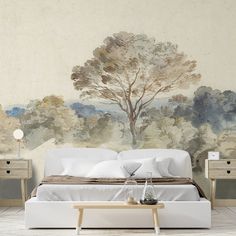 a bed with white sheets and pillows in front of a wall mural that has a tree on it