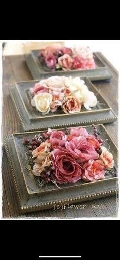 three plates with flowers on them sitting on top of a wooden table next to each other