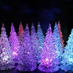 several small glass trees are lit up in the dark