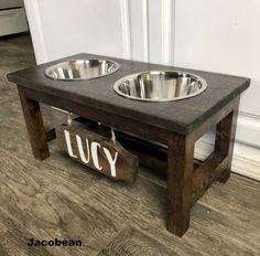 two metal bowls sit on top of a wooden table with the word juicy written across it