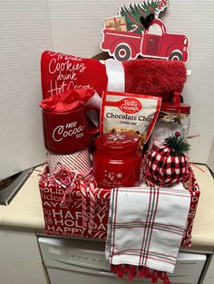 a basket filled with lots of holiday treats and gifts sitting on top of a dishwasher