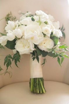 a bouquet of white flowers sitting on top of a chair