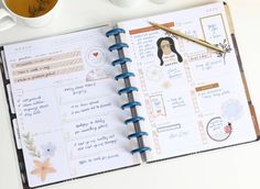 an open planner with stickers on it next to two cups of coffee and a pen