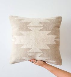 a person holding up a pillow that has been made to look like an arrow