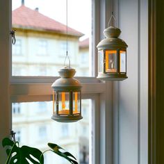 two lanterns hanging from the side of a window