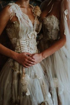 two women in wedding dresses standing next to each other