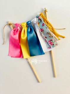 four colorful cotton candy sticks with bows on them