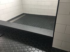 a black and white bathroom with hexagonal tiles