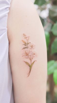 a woman's arm with a flower tattoo on the left side of her arm